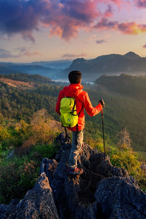 Backpacker standing on sunrise viewpoint at Ja Bo village, Mae hong son province, Thailand.